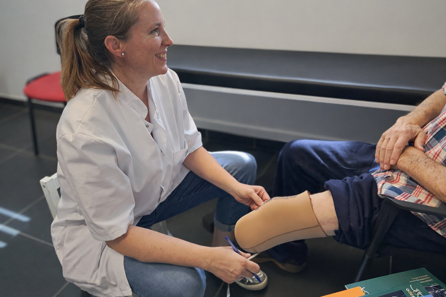 Orthoprothésiste à Valence ajustant une prothèse de jambe sur un patient en consultation.
